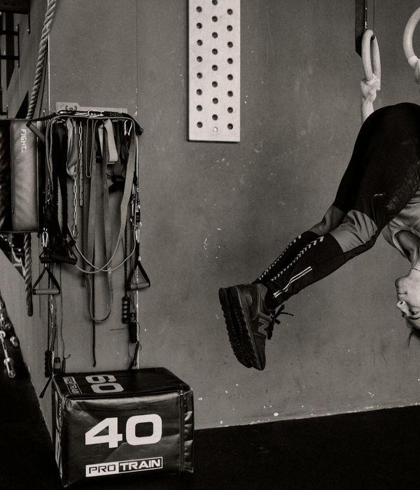 Man performing a complex balancing strength exercise in a modern gym.